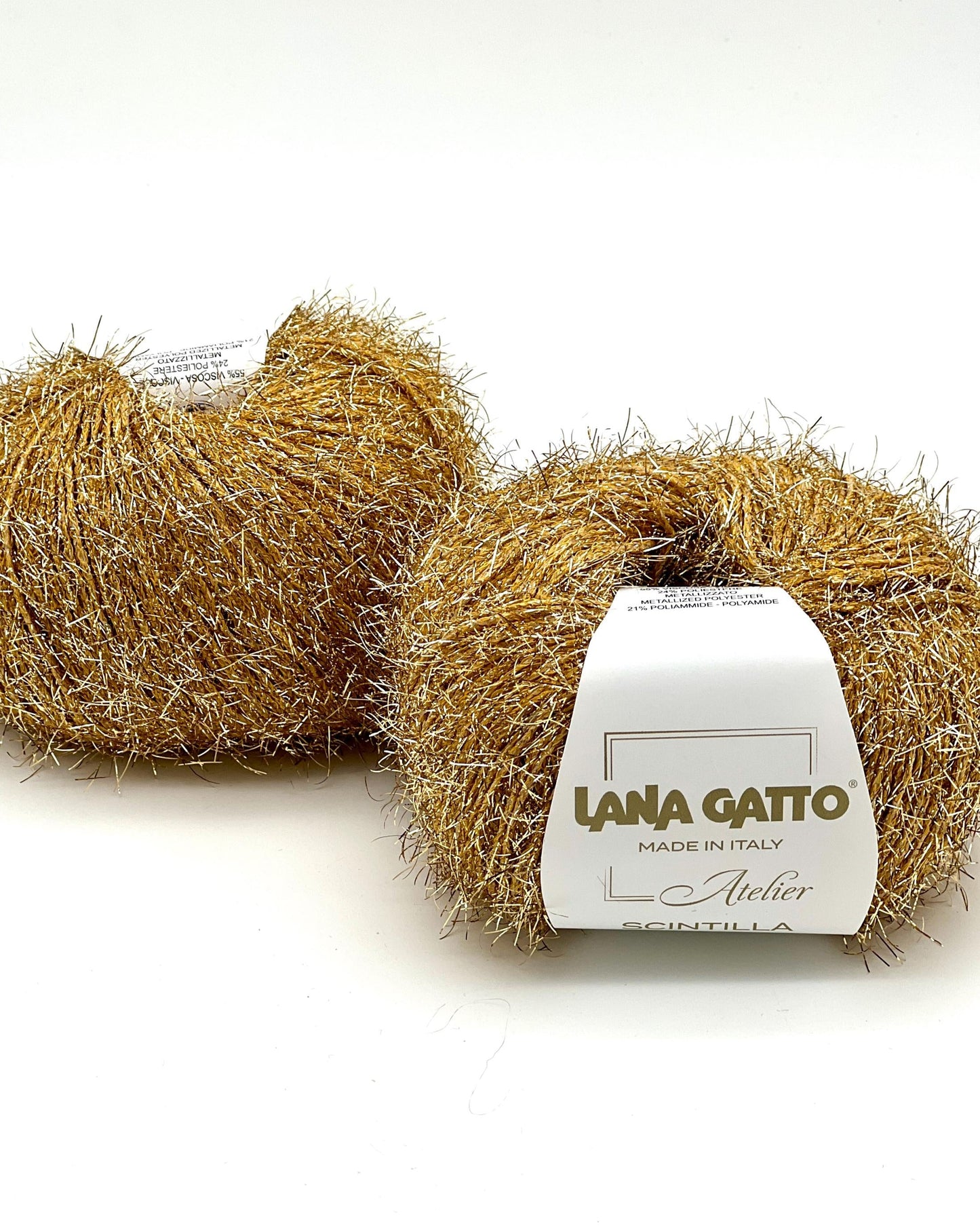 Two balls of gold yarn with a label on a white background