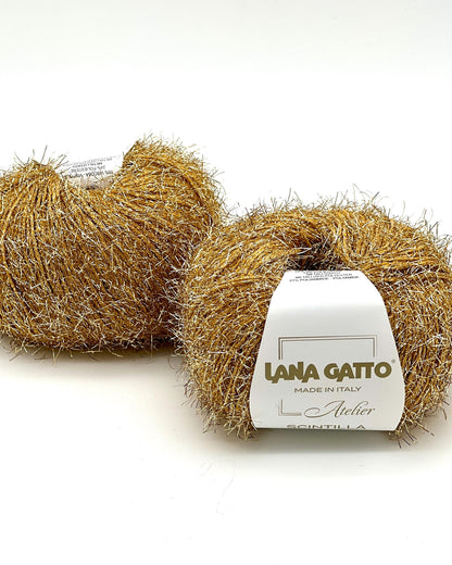 Two balls of gold yarn with a label on a white background