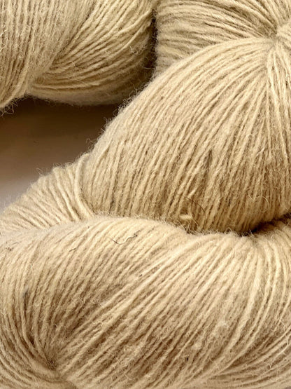 Close-up of beige yarn skeins on a neutral background