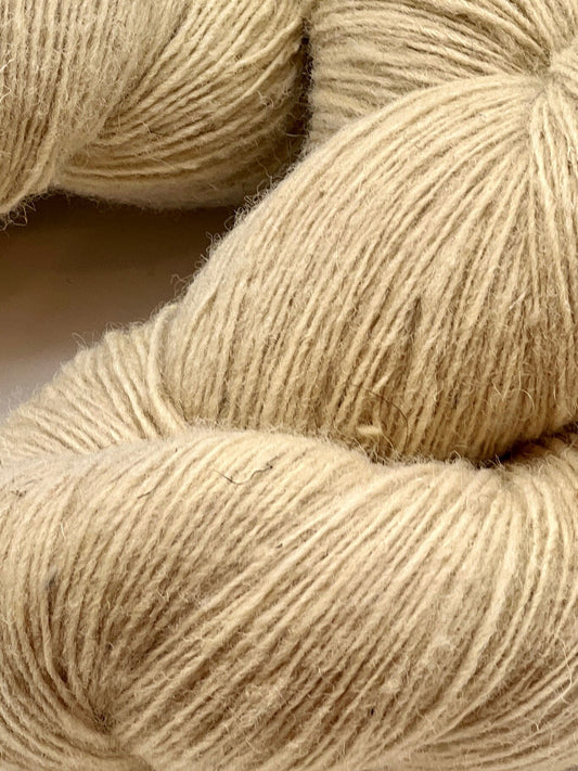 Close-up of beige yarn skeins on a neutral background