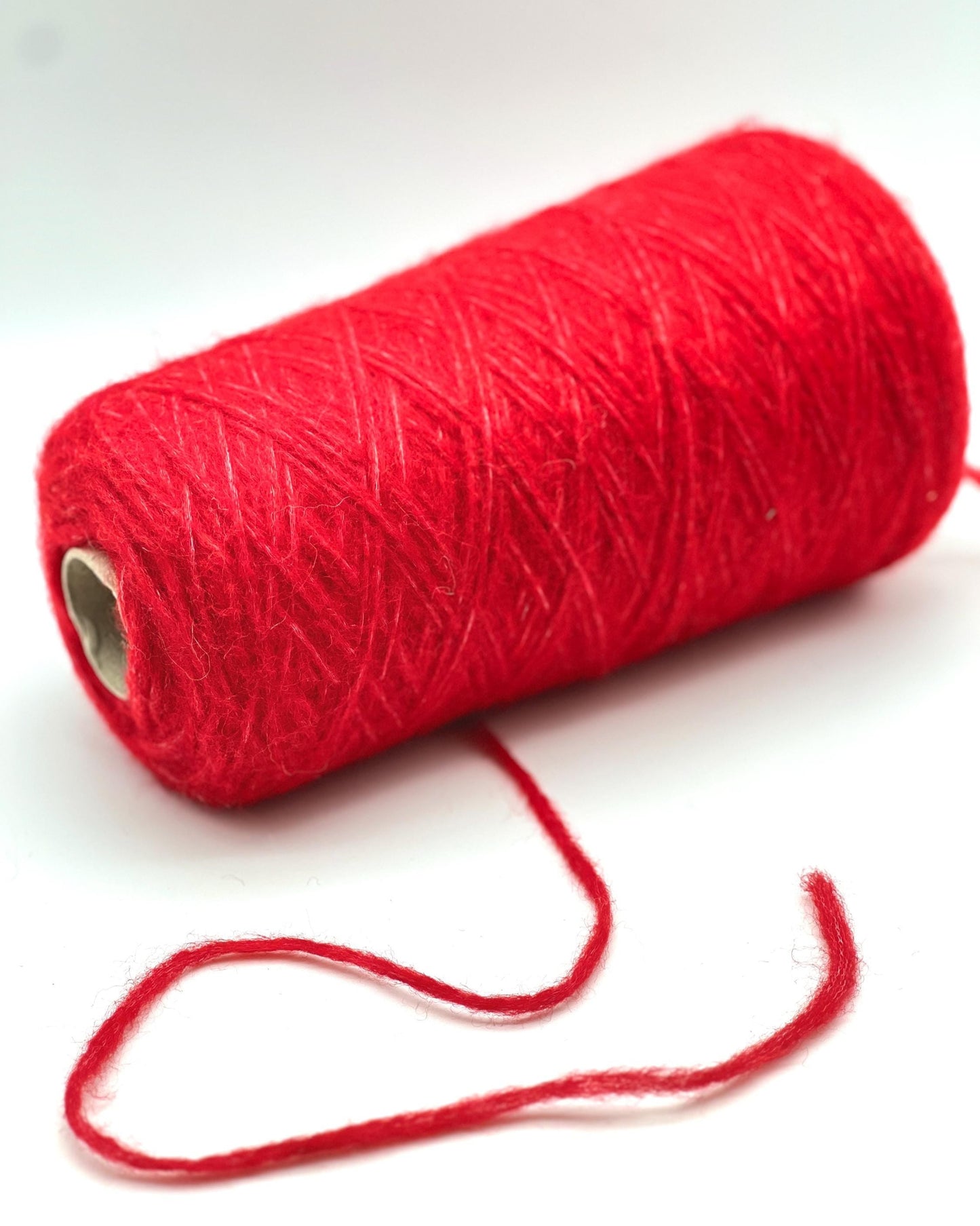 Red yarn spool on a white background