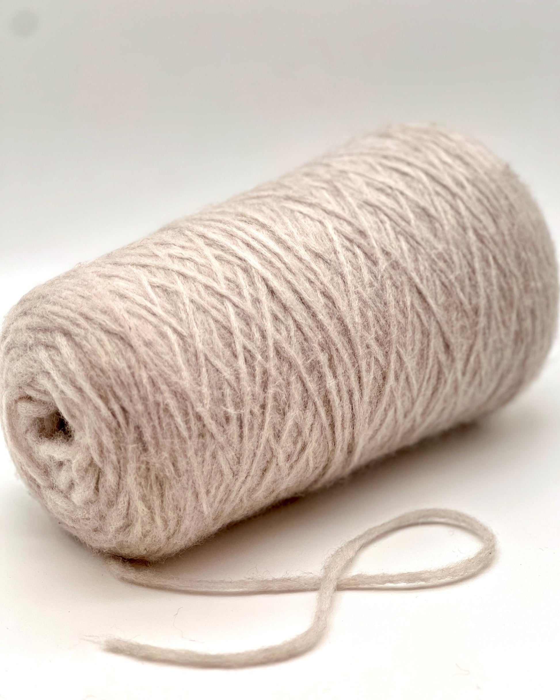 Roll of beige yarn on a white background