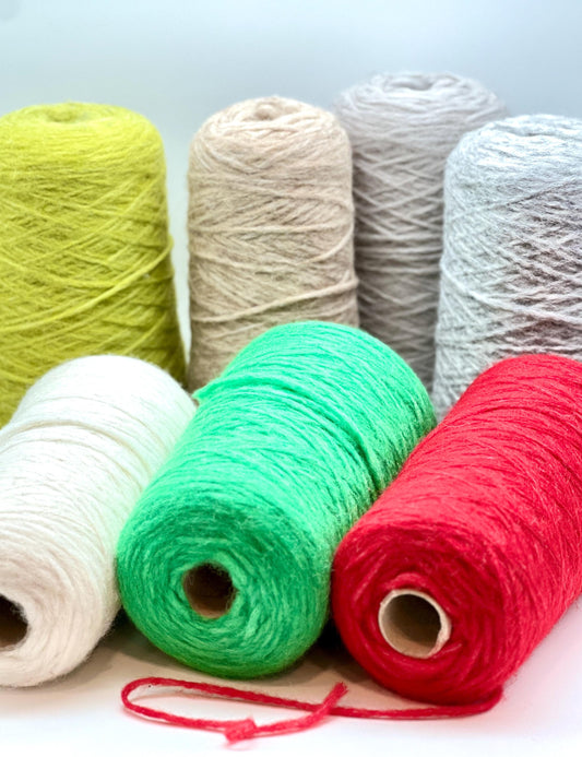 Assorted colorful yarn rolls on a light background