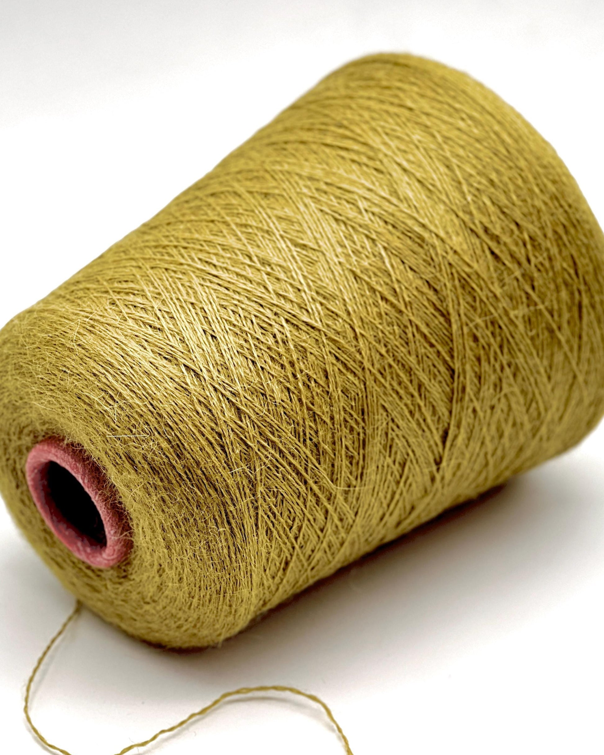 Spool of green yarn on a white background