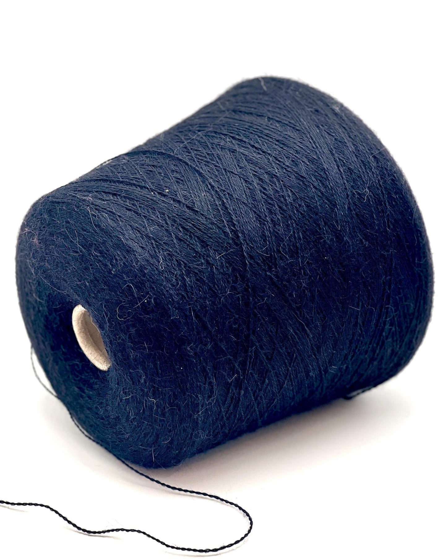 Spool of dark blue thread on a white background