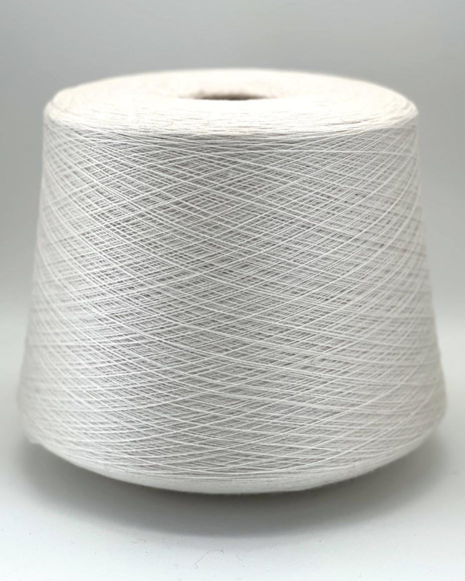 Spool of white yarn on a gray background