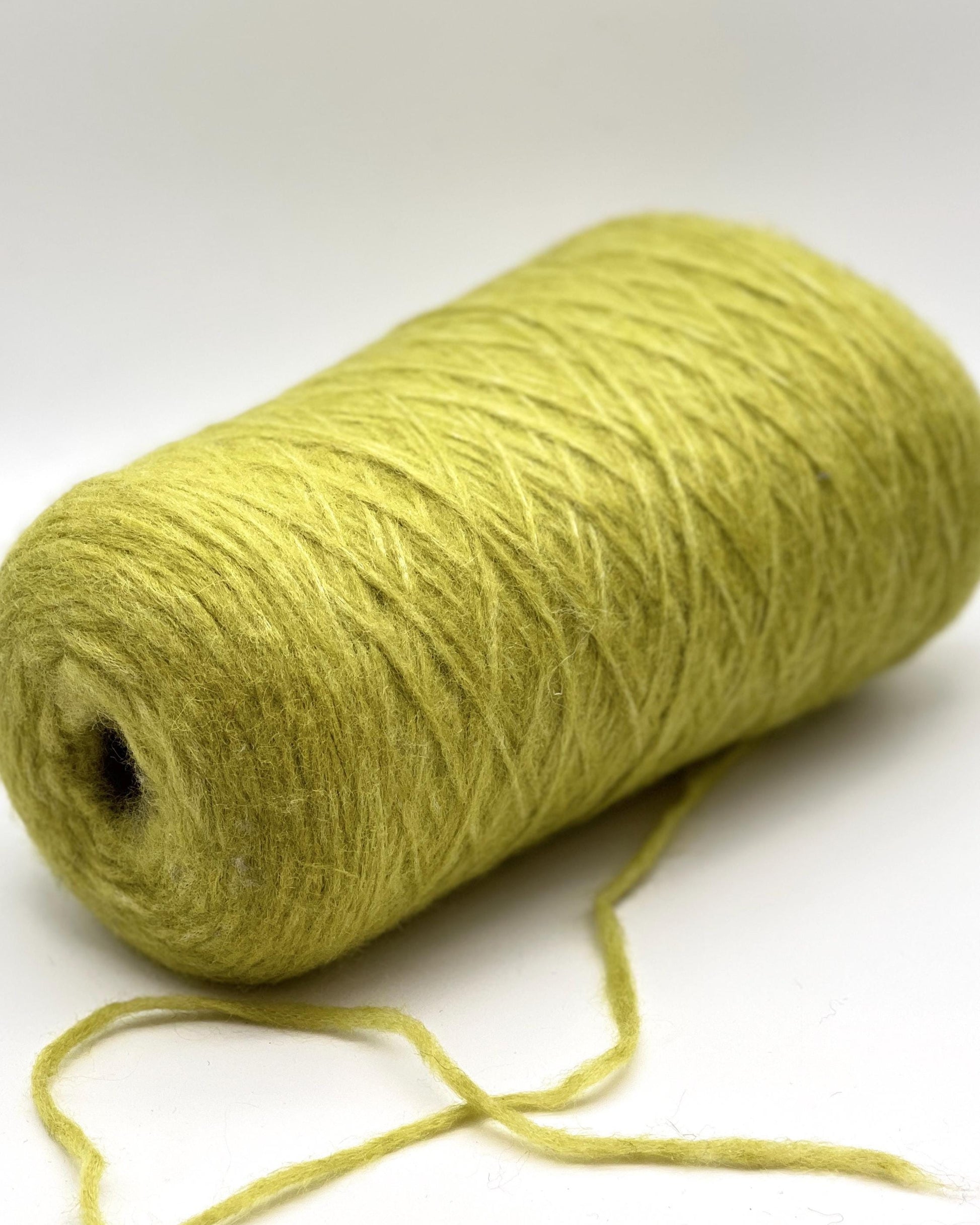 Roll of green yarn on a white background