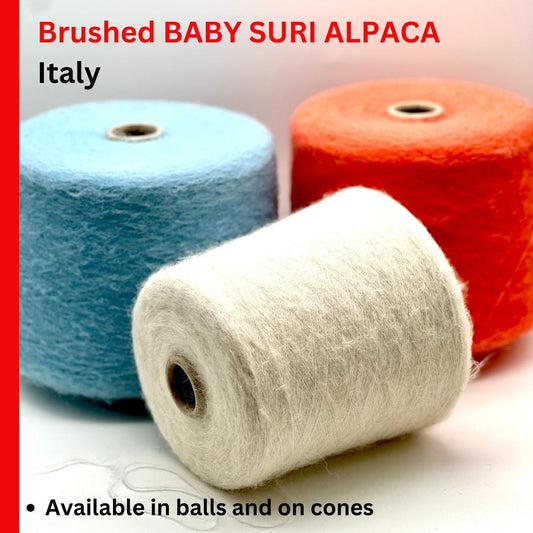 Three spools of yarn in blue, white, and red with text about brushed baby suri alpaca from Italy.