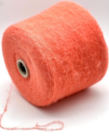 Spool of orange yarn on a white background