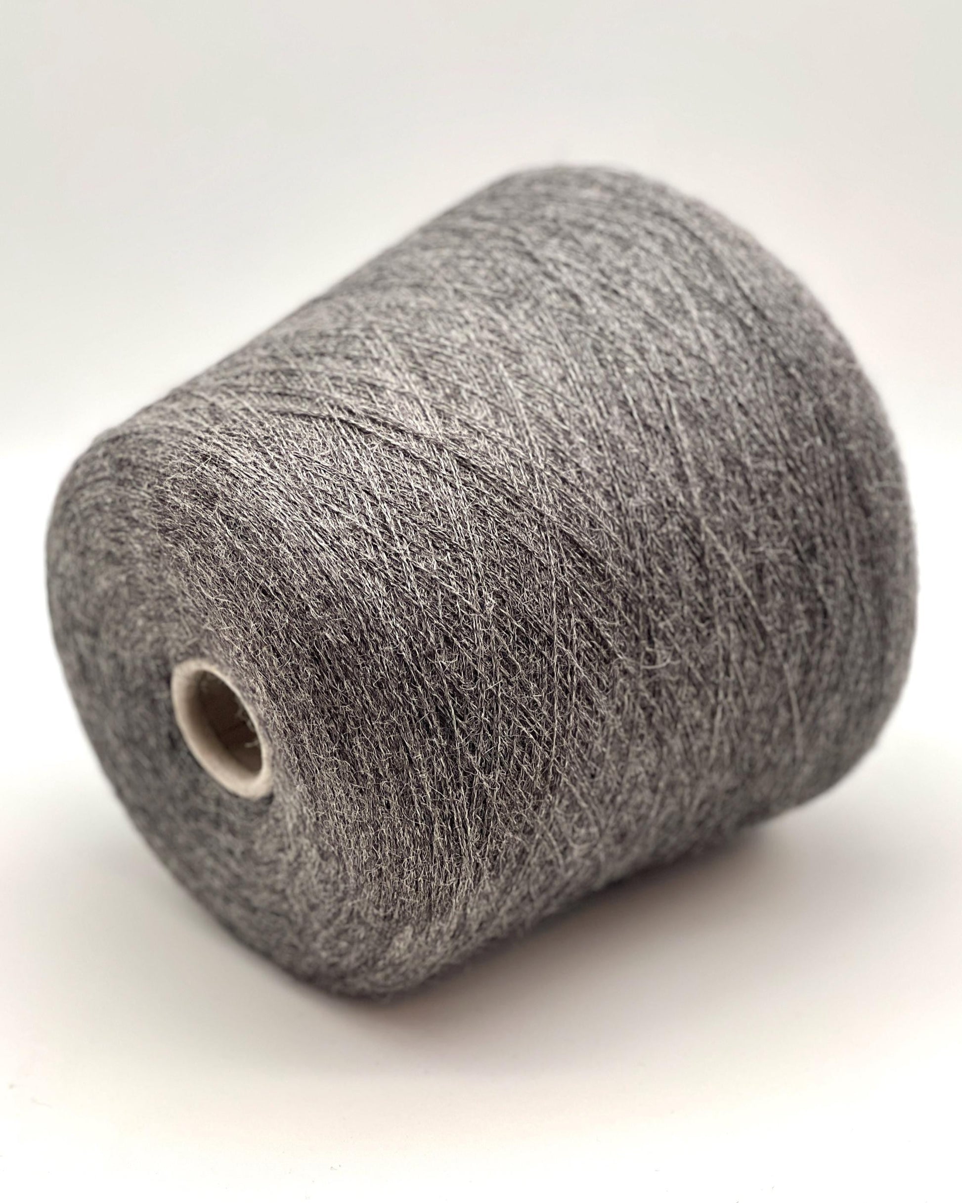 Spool of gray yarn on a white background