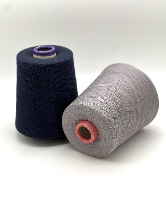 Two spools of yarn, one black and one gray, on a white background
