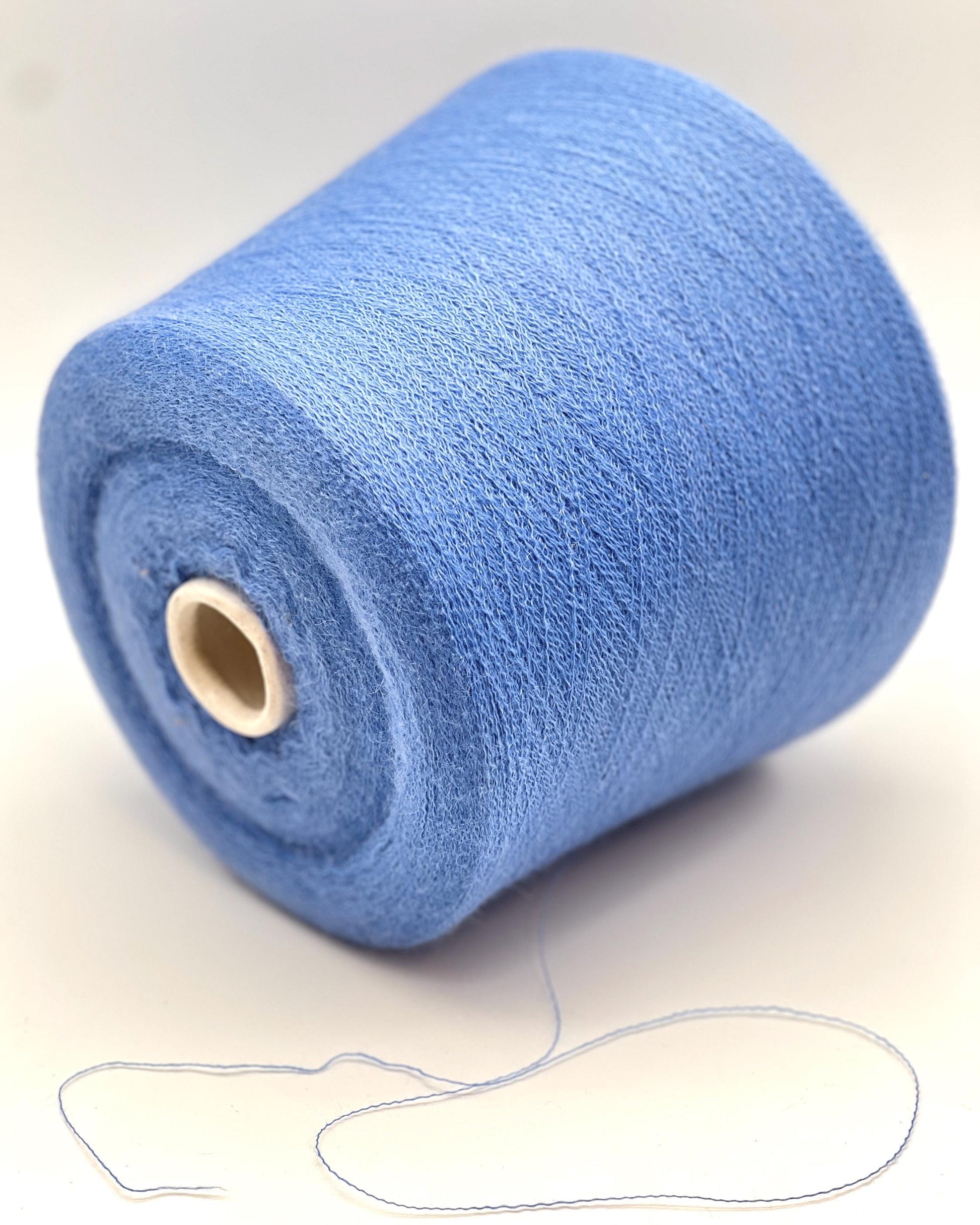 Blue spool of yarn on a white background