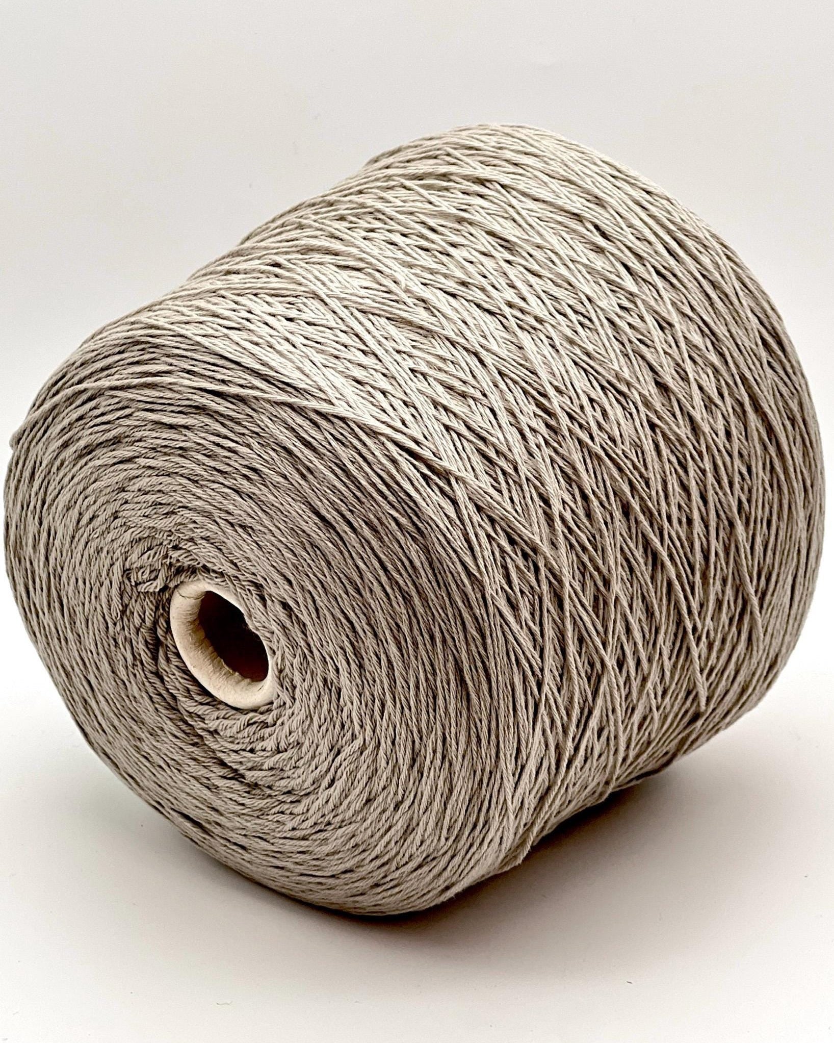 A curated collection of RiGo Supergeelong premium merino wool yarn in a palette of sophisticated neutrals and soft pinks. The image highlights the smooth, even texture and excellent stitch definition of this 100% Italian-made DK/Sport weight fiber. Authentic luxury yarn available at iDOKNiT.com.