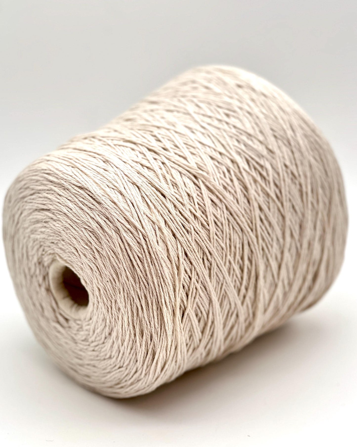 A curated collection of RiGo Supergeelong premium merino wool yarn in a palette of sophisticated neutrals and soft pinks. The image highlights the smooth, even texture and excellent stitch definition of this 100% Italian-made DK/Sport weight fiber. Authentic luxury yarn available at iDOKNiT.com.