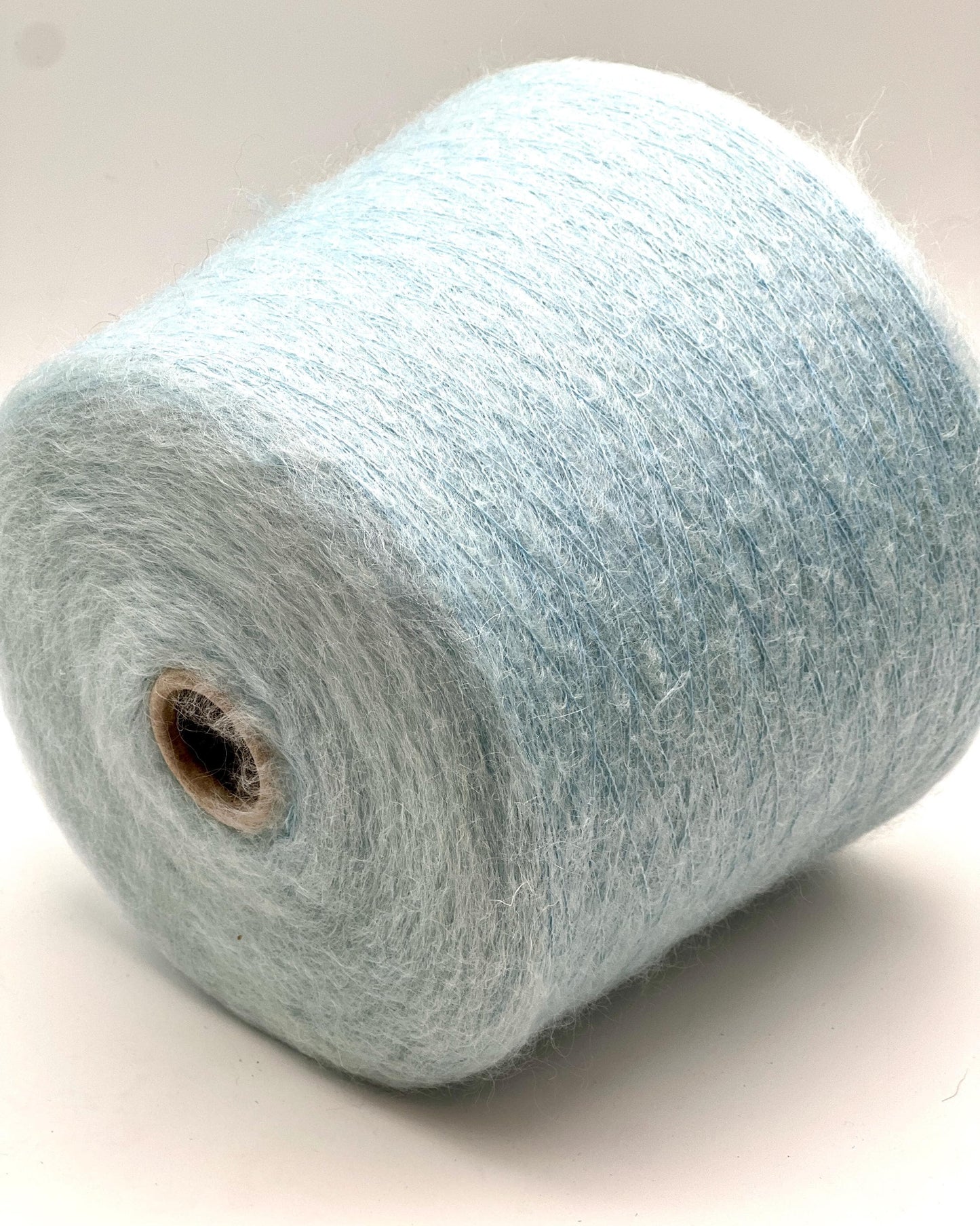 Spool of light blue yarn on a white background