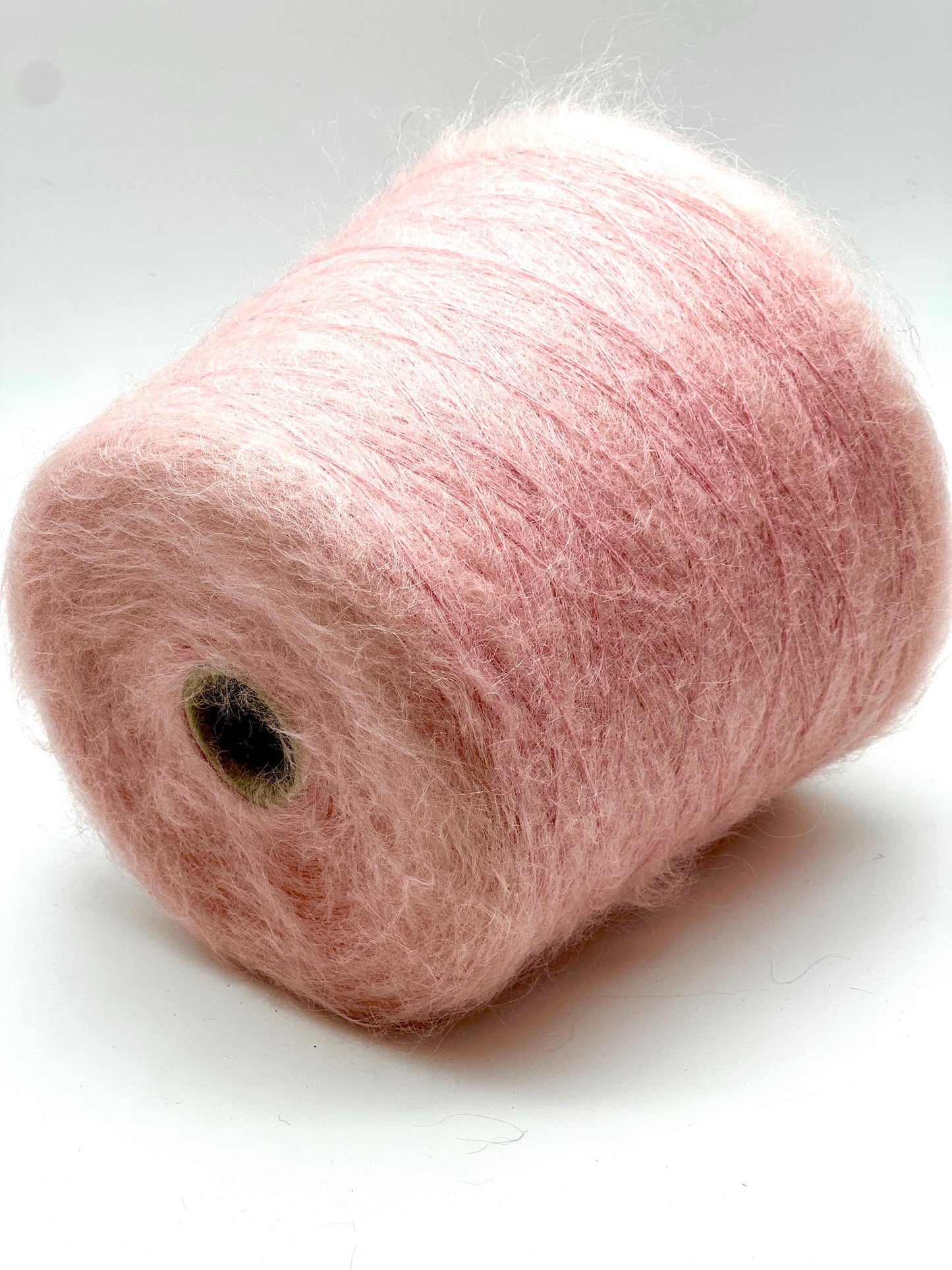Pink yarn spool on a white background