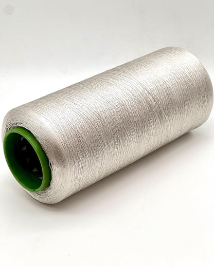 Spool of silver thread on a white background