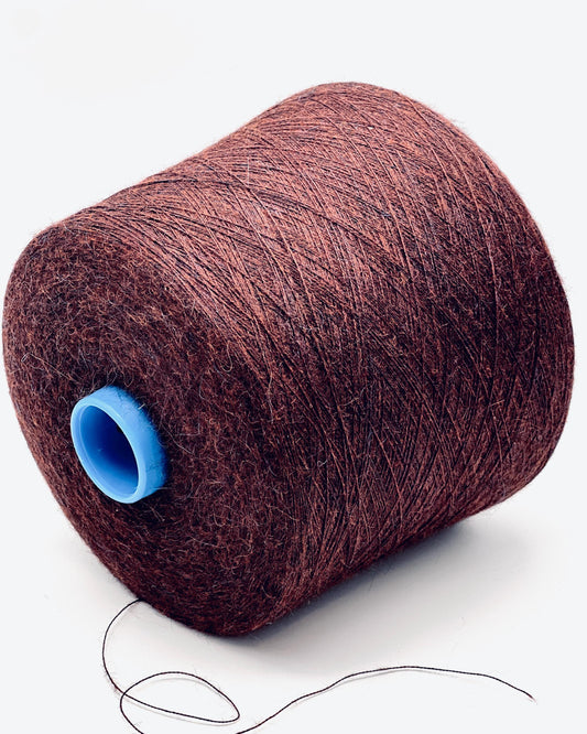 Spool of brown thread with a blue core on a white background