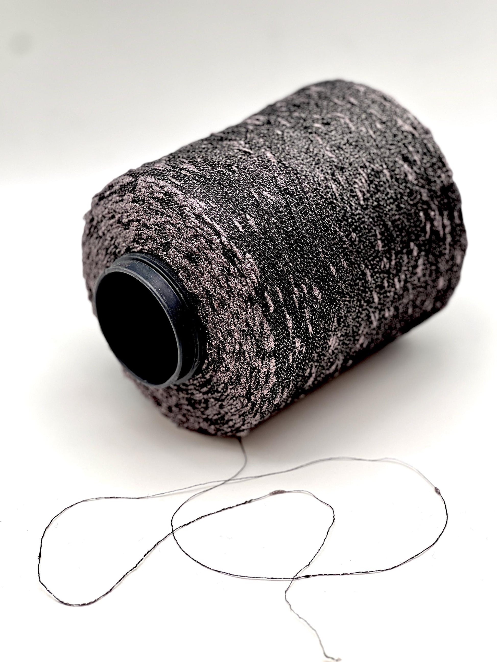 Spool of black and gray yarn on a white background