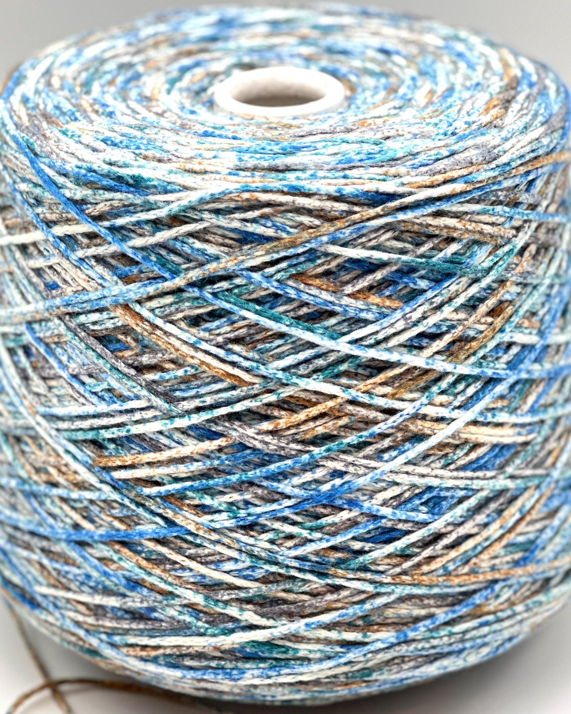 Spool of multicolored yarn on a white background