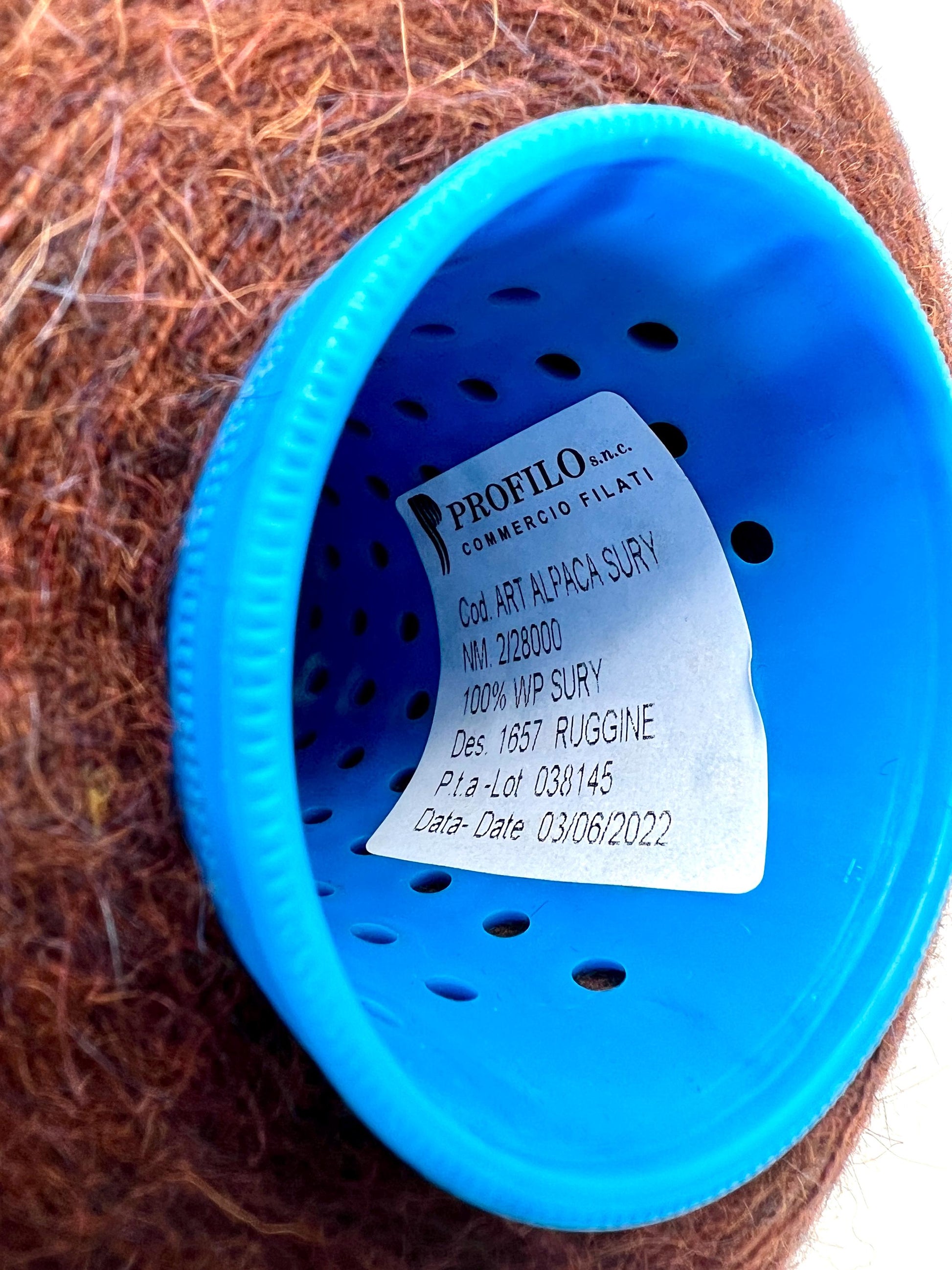 Blue plastic container with a label on a brown fibrous material