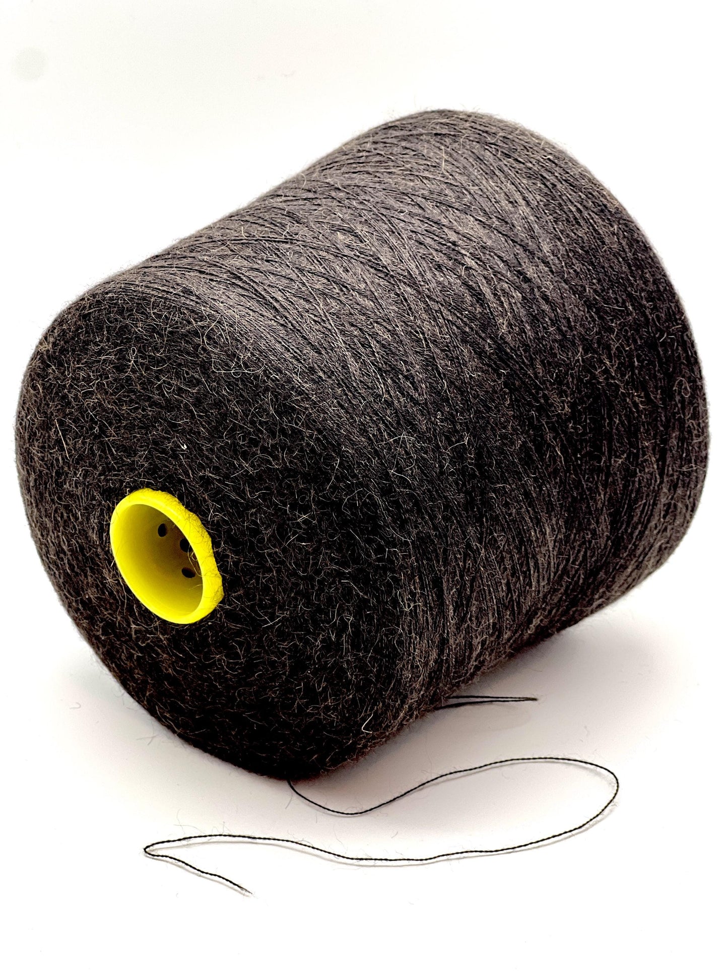 Spool of gray thread with a yellow core on a white background