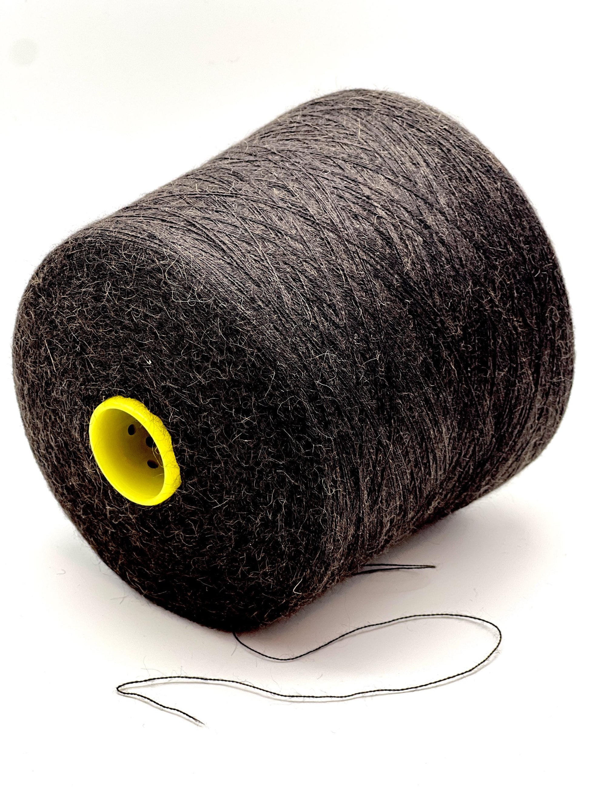 Spool of gray thread with a yellow core on a white background