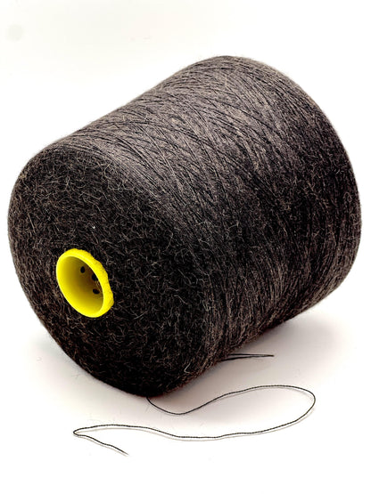 Spool of gray thread with a yellow core on a white background