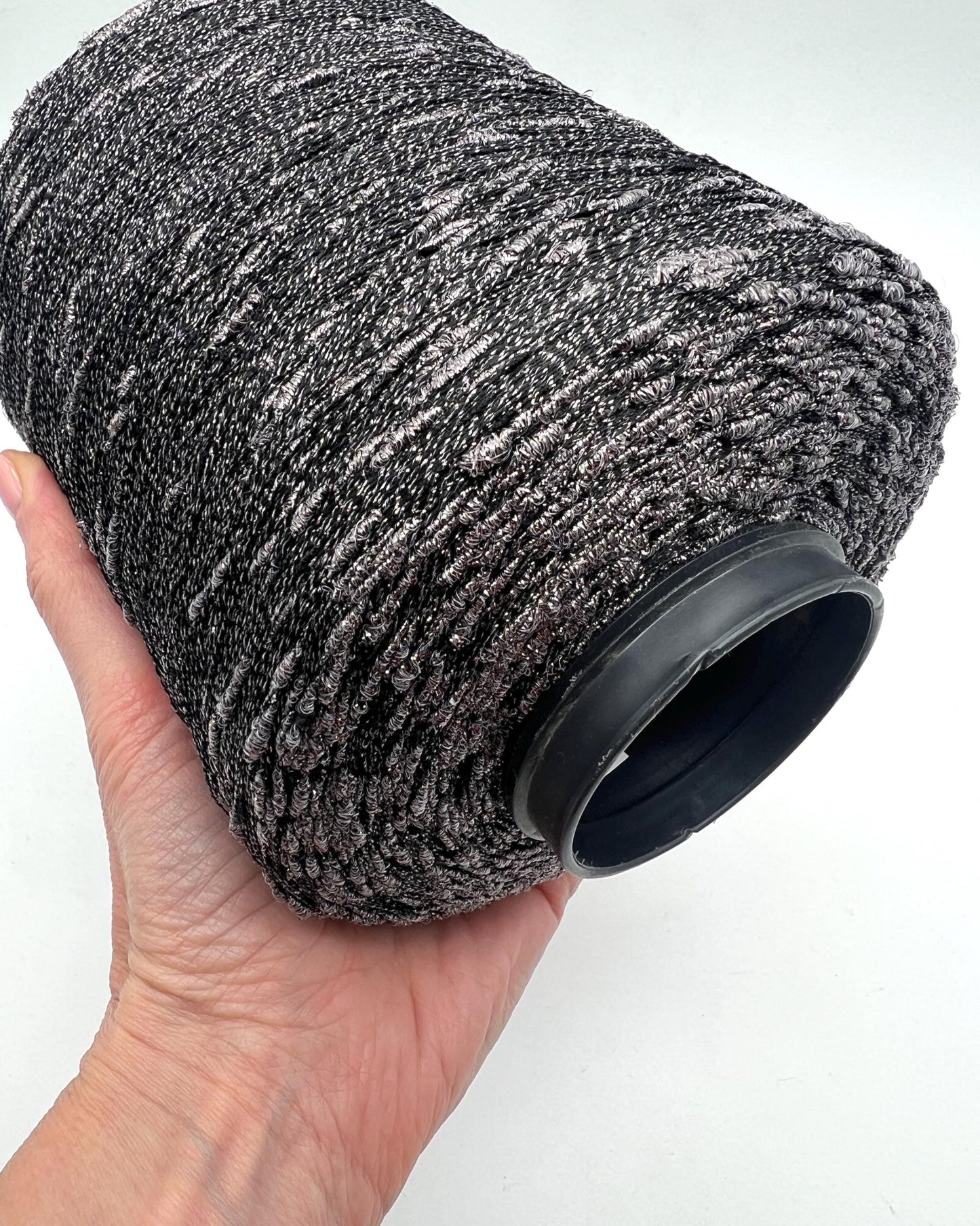Textured black and gray air filter held in a hand against a white background