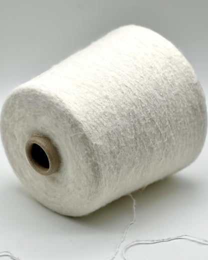 Spool of white thread on a light gray background