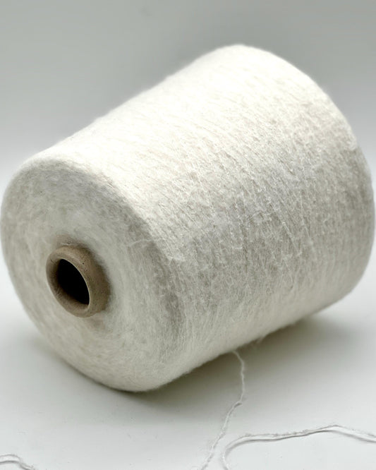Spool of white thread on a light gray background