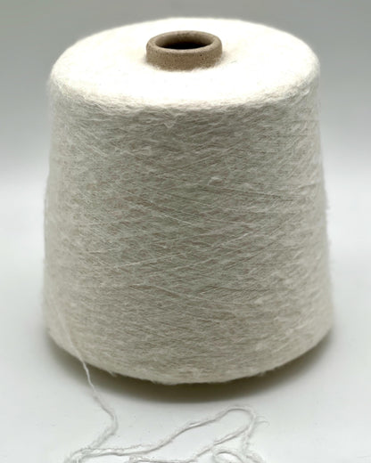 Spool of white yarn on a light gray background