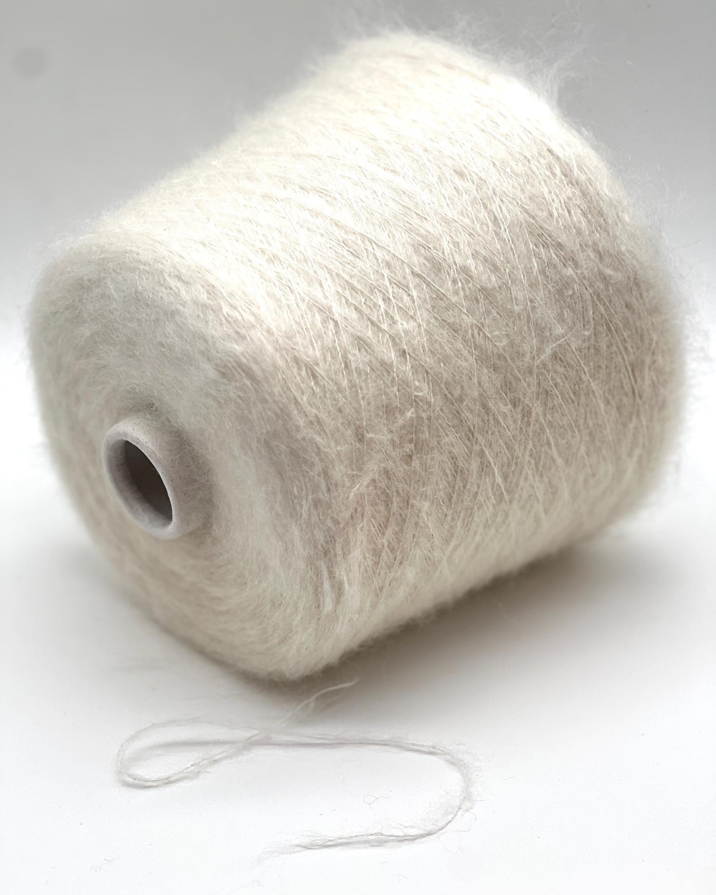 Spool of white yarn on a white background