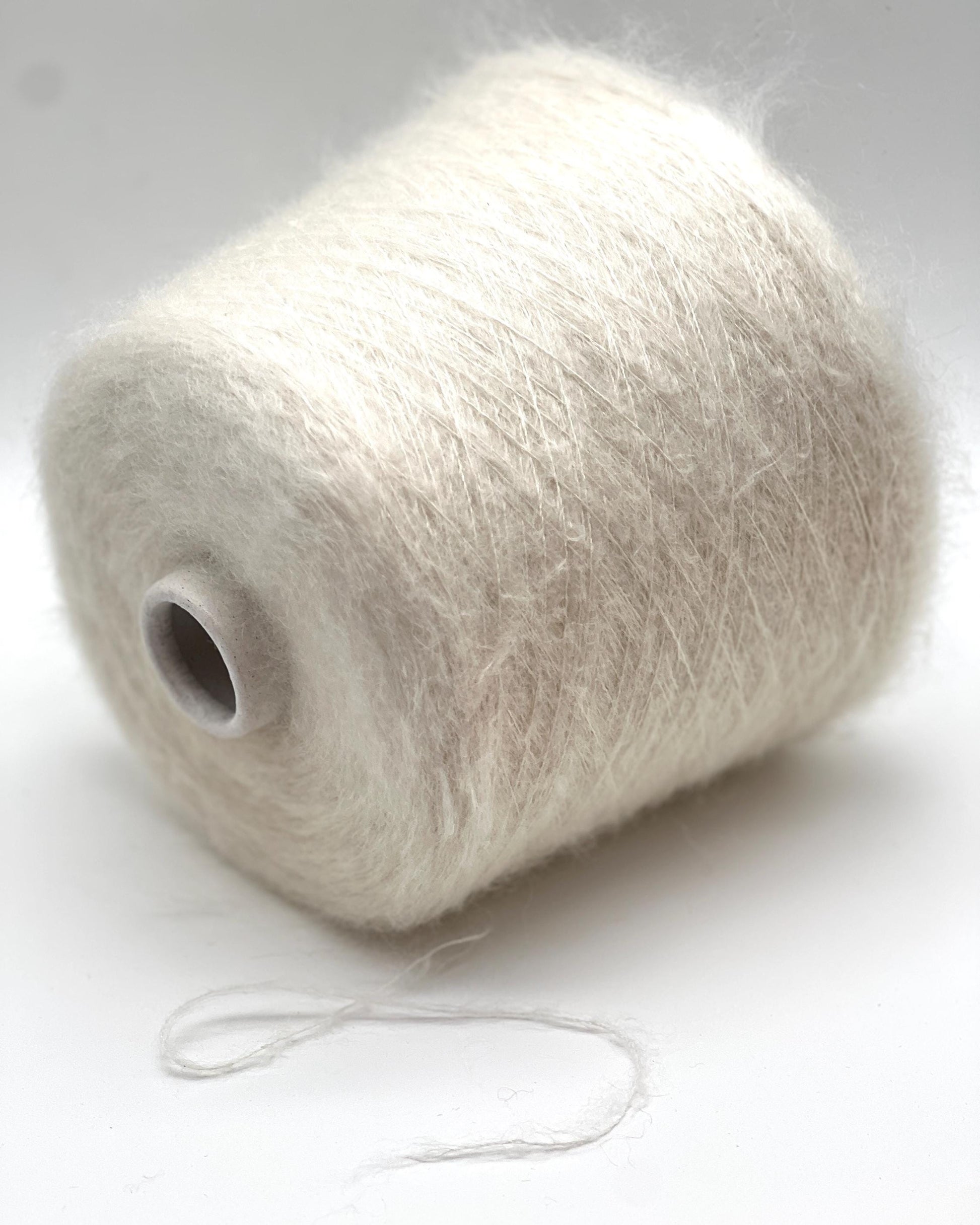Spool of white yarn on a white background