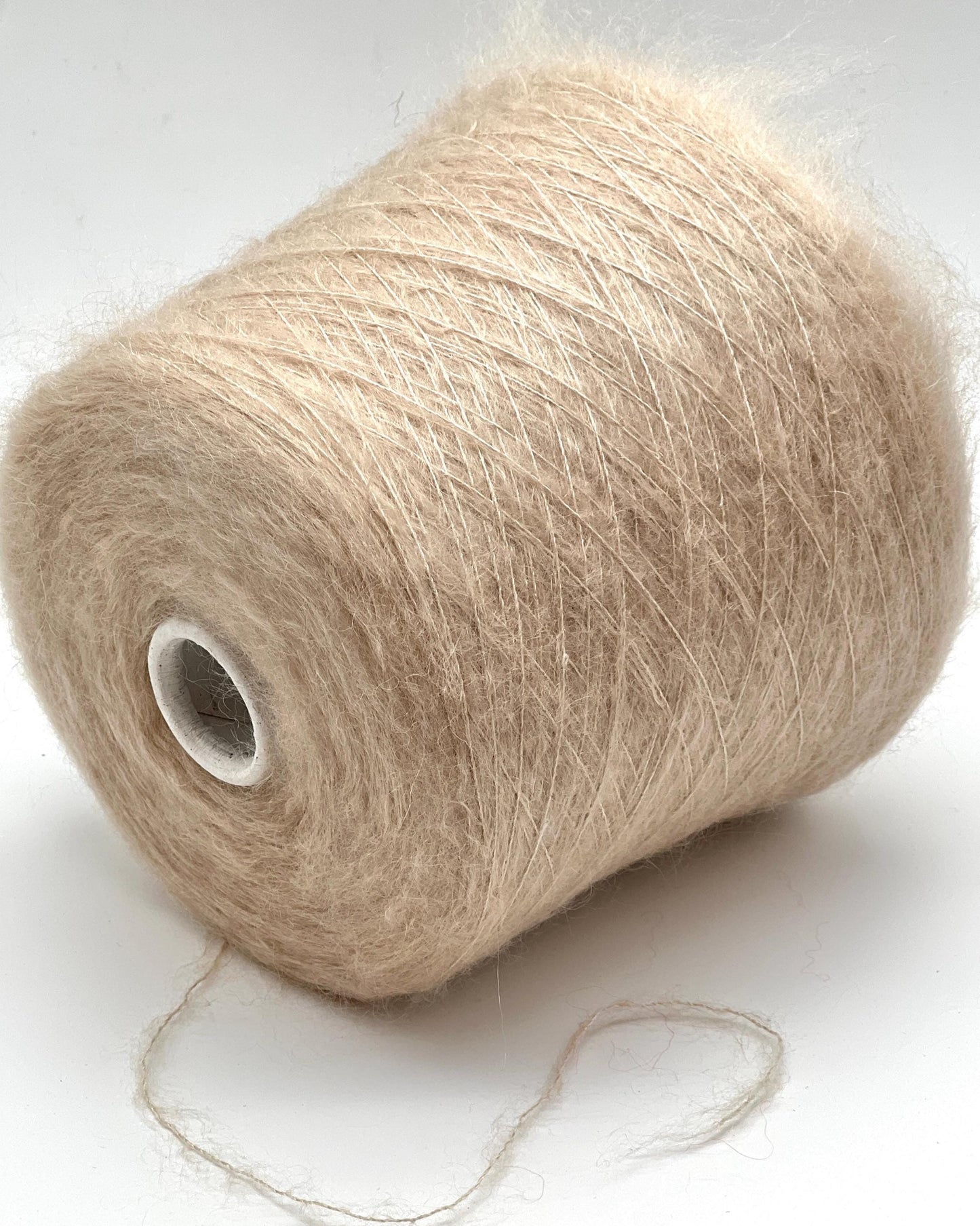 Spool of beige yarn on a white background
