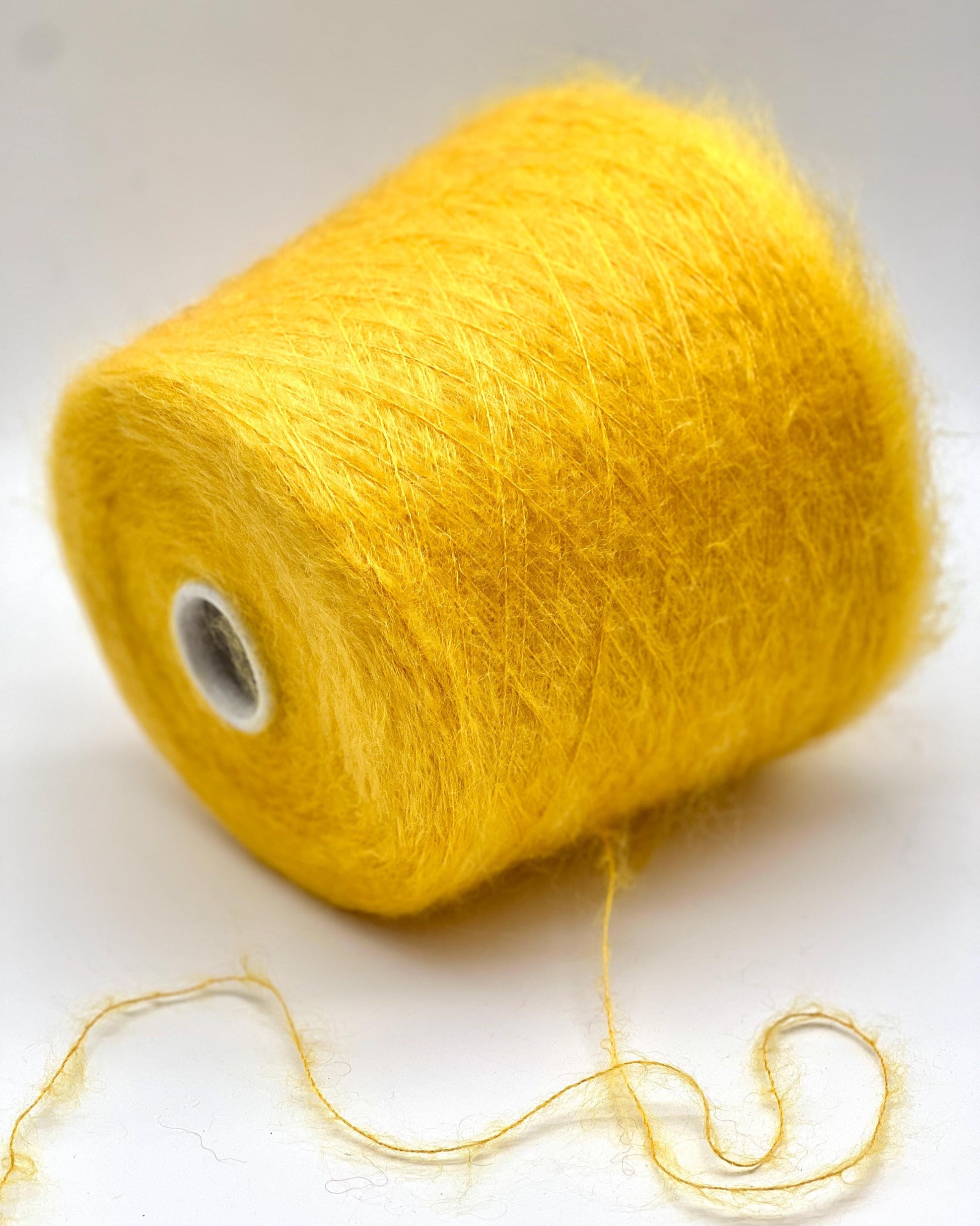 Yellow yarn spool on a white background