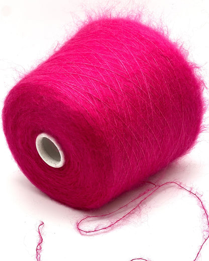 Spool of bright pink yarn on a white background