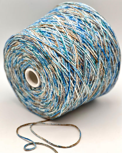 Spool of blue and beige yarn on a white background