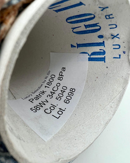 Close-up of a label inside a shoe with text and branding.