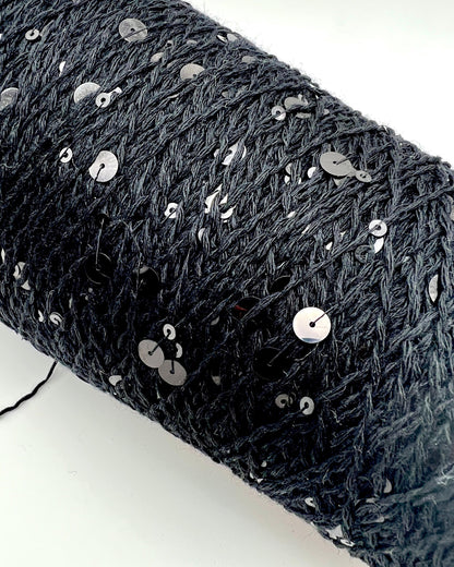 Black textured fabric with silver sequins on a white background