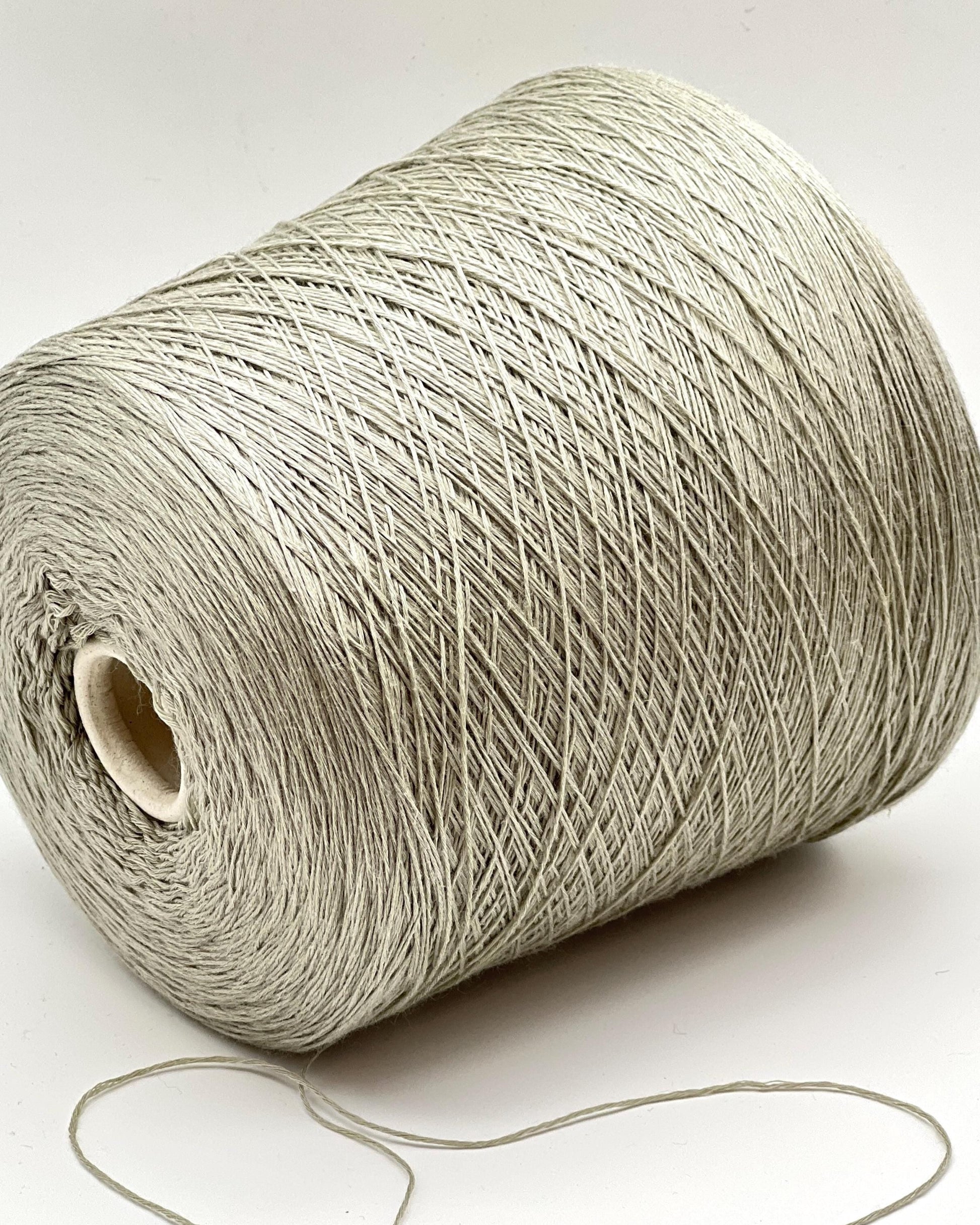 Roll of beige yarn on a white background