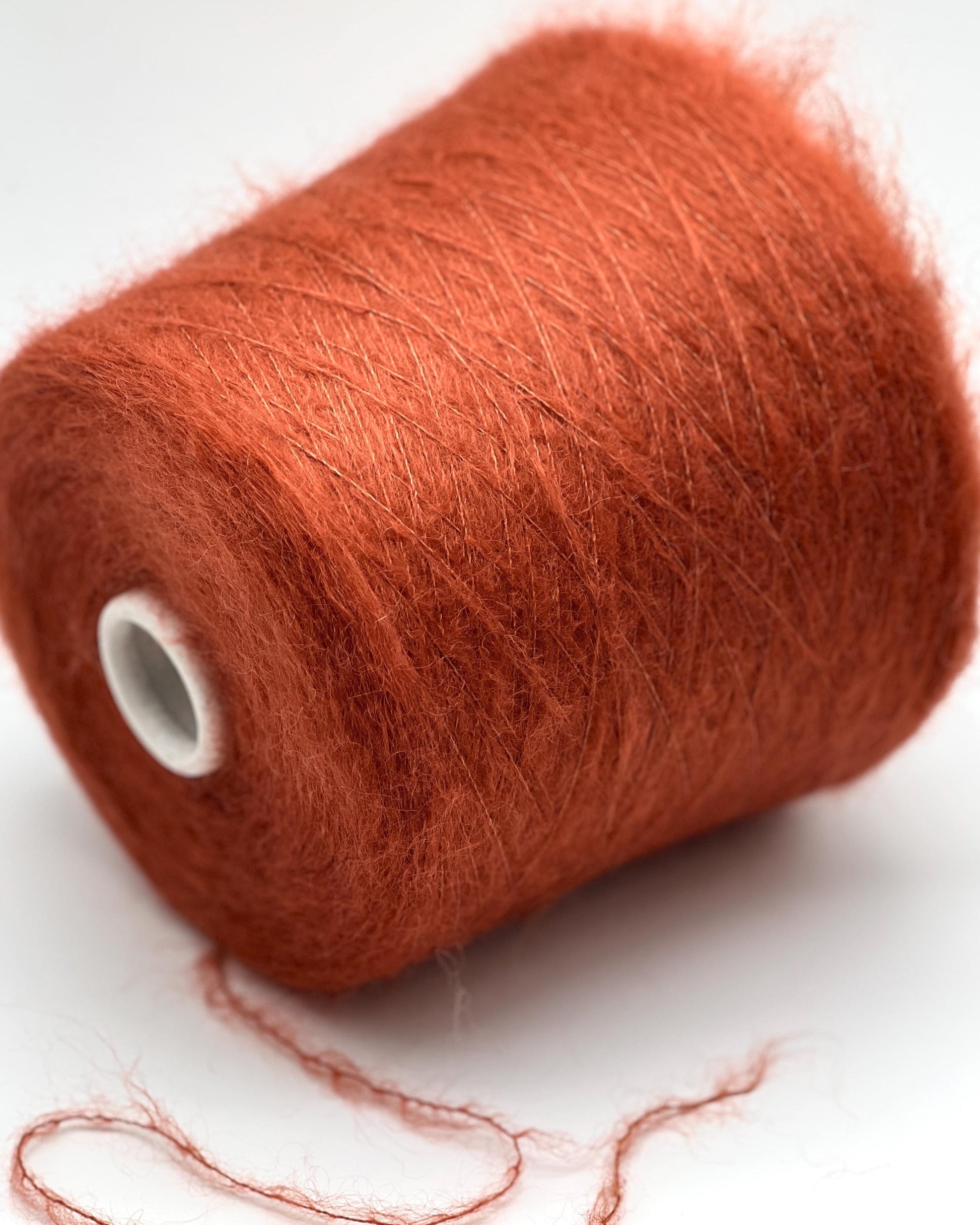 Spool of red yarn on a white background