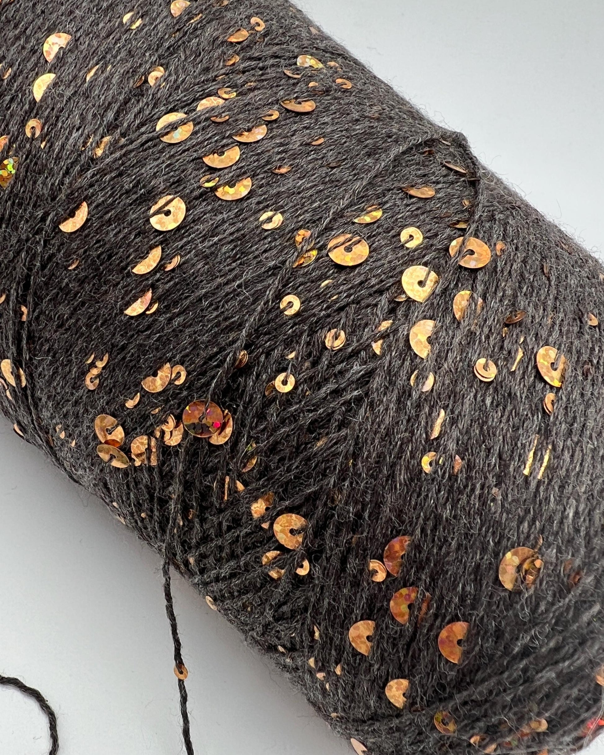 Gray yarn with gold sequins on a white background