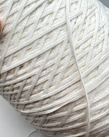Close-up of a ball of white yarn on a light background