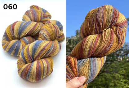 Small-batch dyed heritage skeins of 100% Latvian Dark-Headed Sheep Wool in earthy multicolor gradients like Green-Brown #052. The image shows the rustic single-ply texture and the sheep breed origin, representing the authentic wool traditions of Paces Vilnas Fabrika, Latvia. Available at iDOKNiT.com.