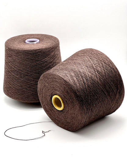Two brown spools of yarn on a white background