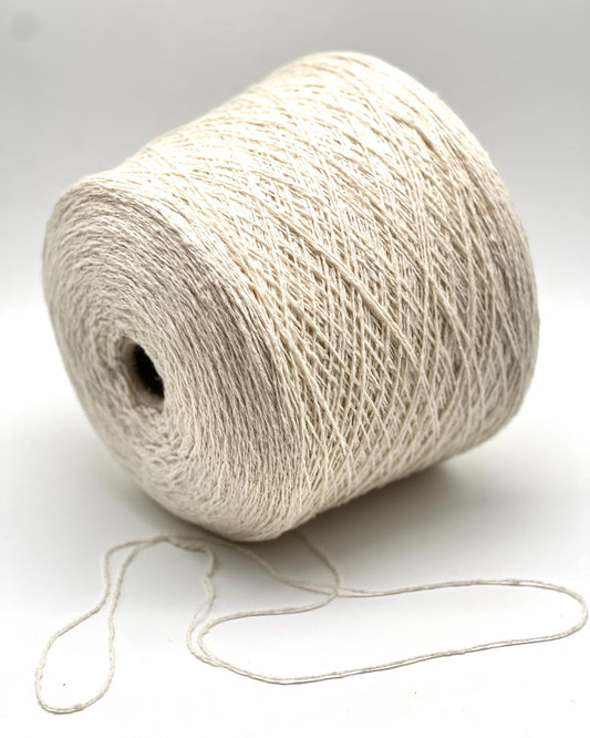 Spool of white yarn on a light gray background