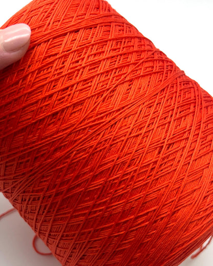 Luxury COTTON SILK lace-weight yarn by Botto Giuseppe, Italy – 55% silk and 45% cotton blend, super soft with an elegant natural sheen. Shown in vibrant coral red on a cone. Ideal for summer tops, lightweight layering, and luxury blending. Premium Italian yarn available at iDOKNiT.com.