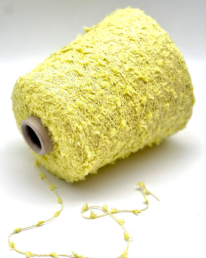 Spool of yellow yarn on a white background