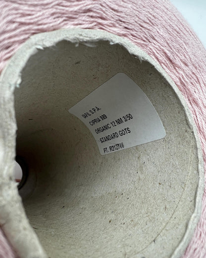 Close-up of a roll of pink yarn with a label inside